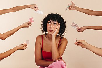 Eine Frau muss sich zwischen mehreren Verhütungsmitteln entscheiden