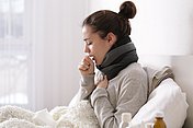 Erkältete Frau hustet Eine erkältete Frau leidet an Husten.