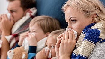 Eine komplette Familie leidet an einer Erkältung mit Schnupfen.