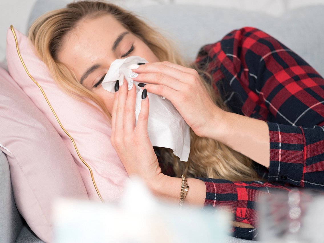 Eine erkältete Frau mit Schnupfen liegt krank im Bett. © studio v-zwoelf/adobe.stock