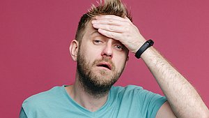Ein Mann hat eine Erkältung und hohes Fieber.